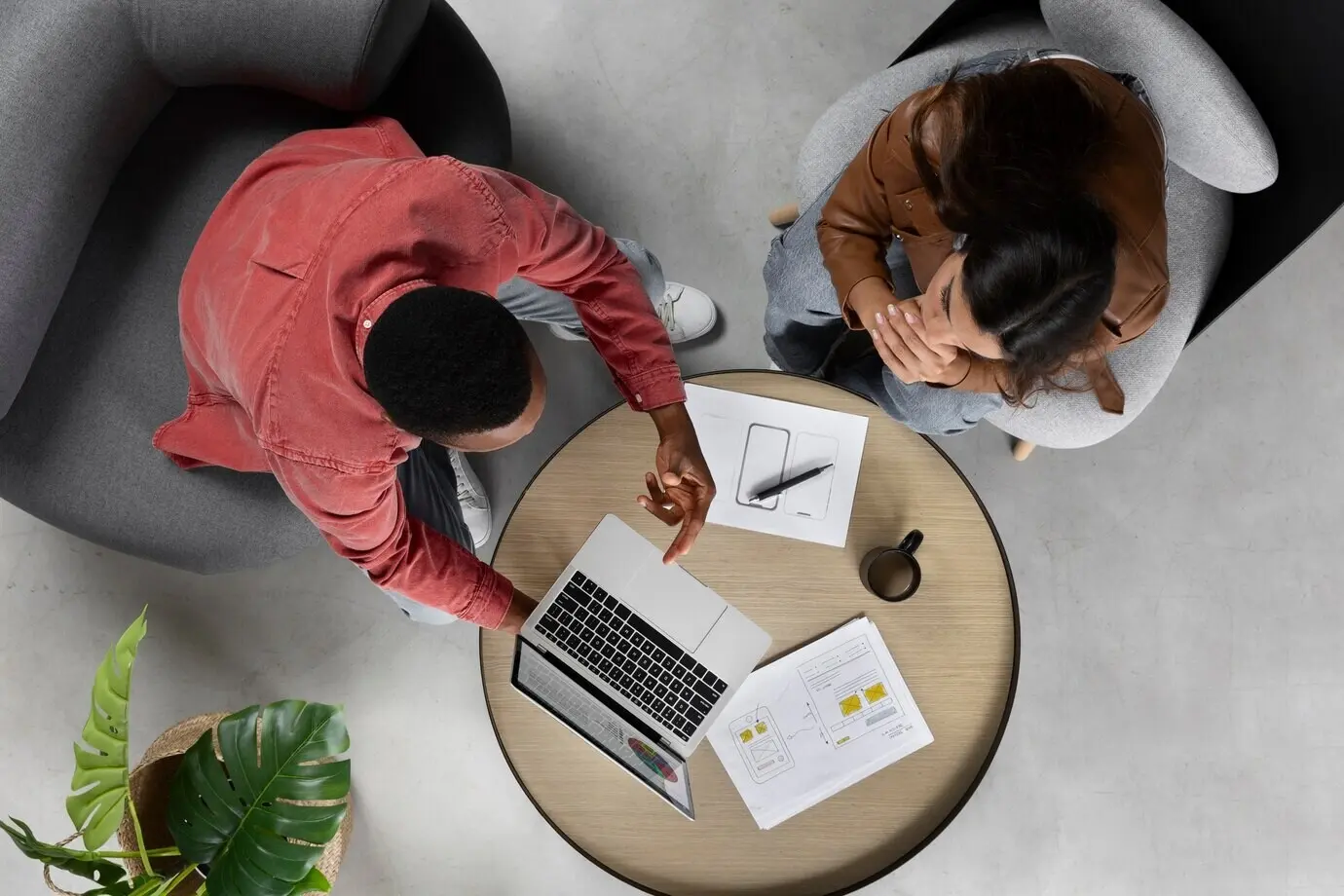 Draufsicht: Menschen, die mit einem Laptop arbeiten.